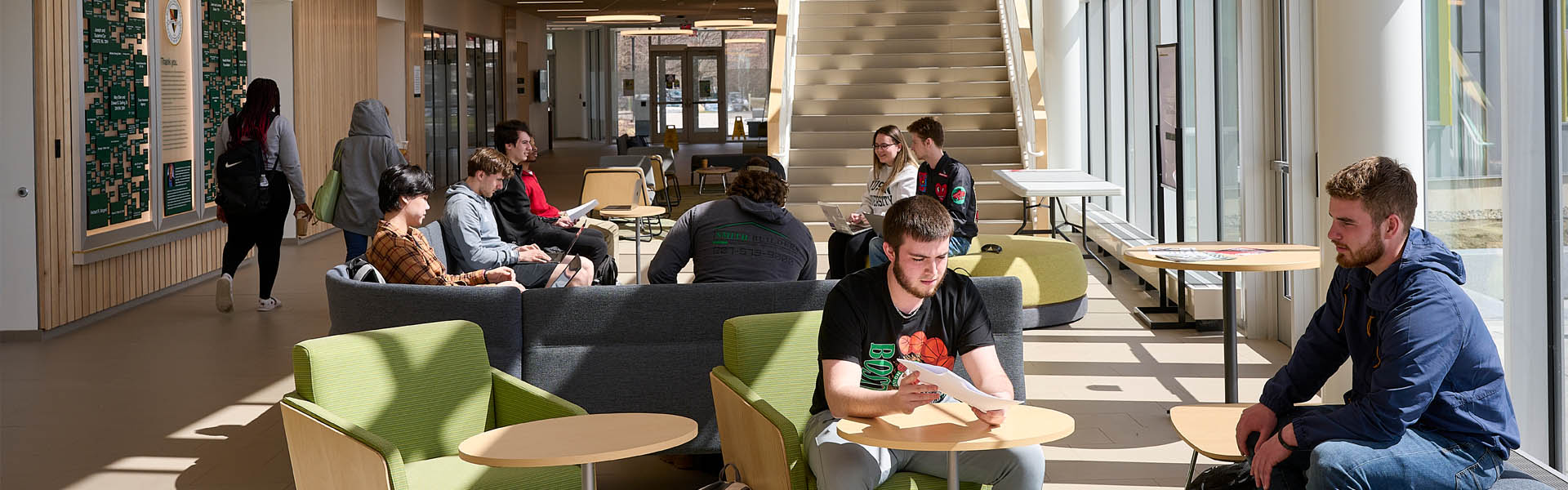 Interior view of Harold Alfond Hall where students are seated, talking and studying