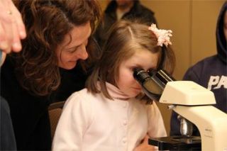 Child looking through microscope.