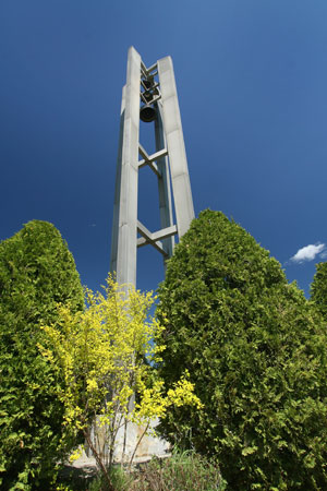 The Husson Bell Tower on a sunny day with the blue sky behind it..