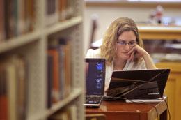 Student in the library researching with her laptop