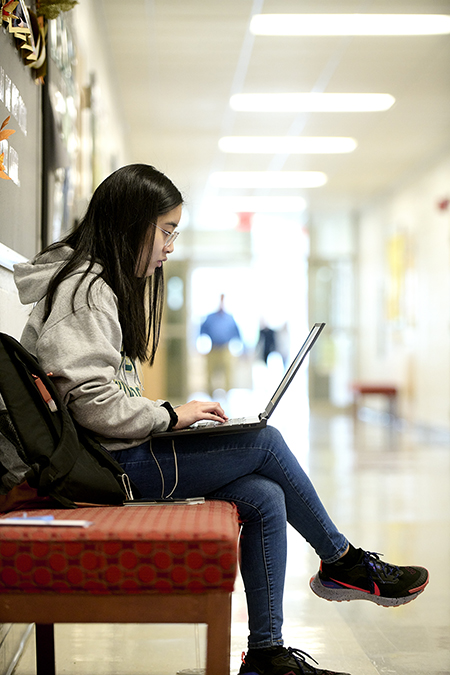 A student works on a laptop in Peabody Hall