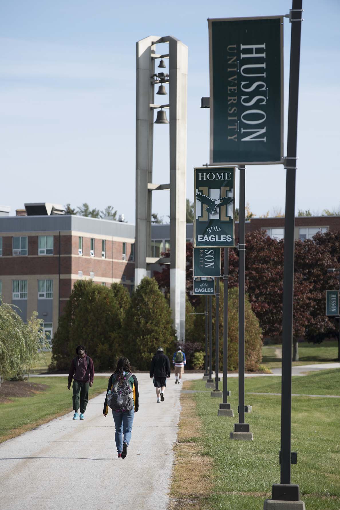 Students walk on a path on the Husson University campus