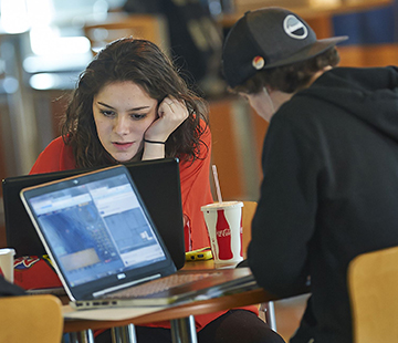 students studying in the campus center of Husson University