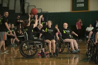 Students participating in wheelchair basketball event.