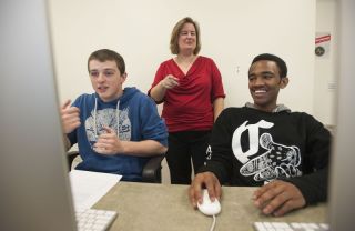 Laura Gurney with two male students programming 