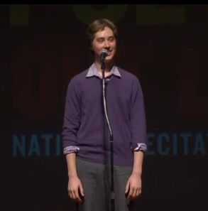 High school student on stage reciting poetry