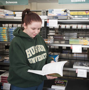 student looks at a book in the bookstore