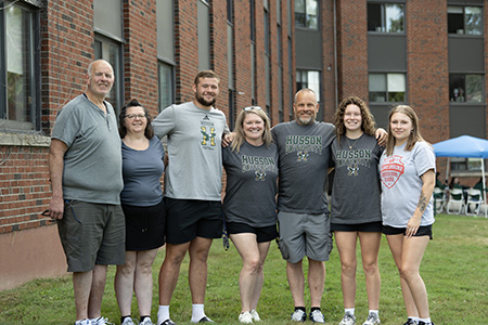 students stand with their families outside of the residence halls