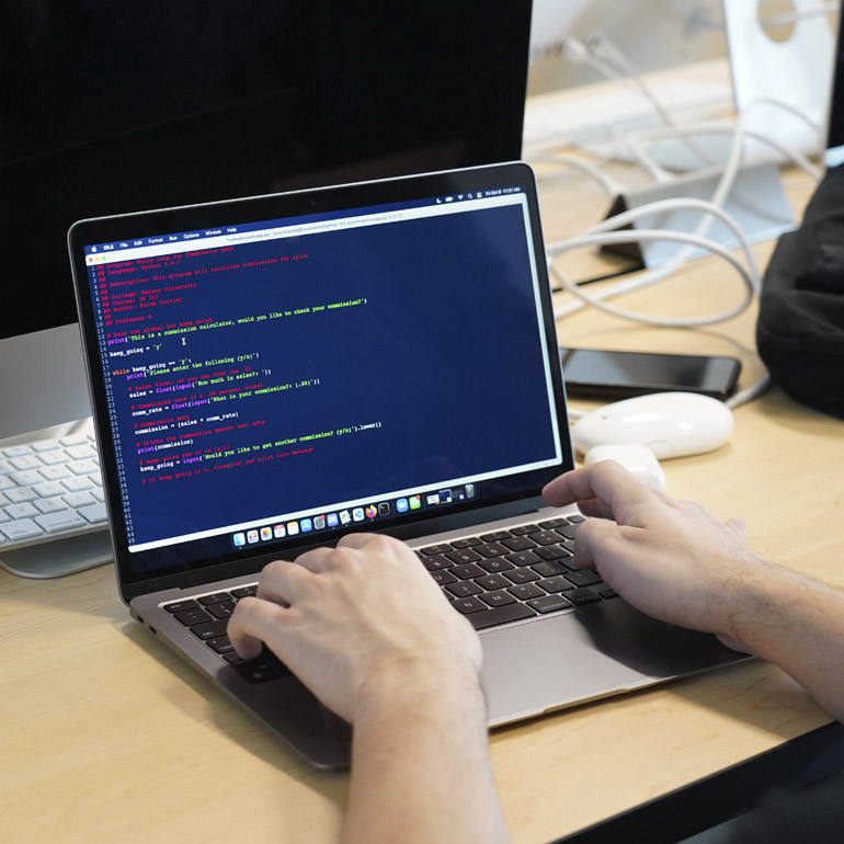 A student works on a laptop using a software development program