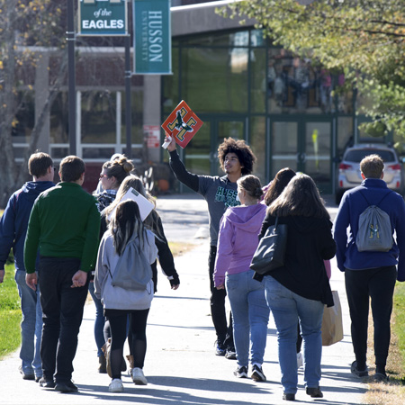 A counselor gives students and parents a guided tour of campus