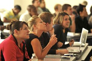 Students at desks in a classroom with attention to front of room