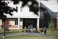 students walking on campus in front of the Beardsley Meeting House