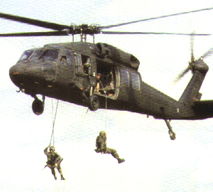 An image of soldiers hanging out of a helocopter.