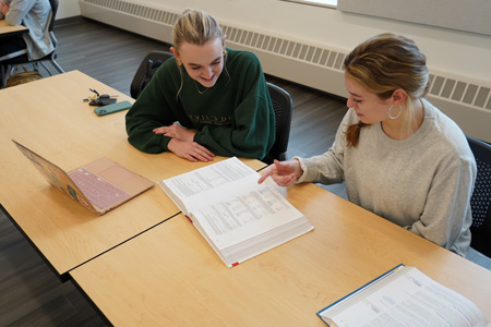 students working in classroom with faculty