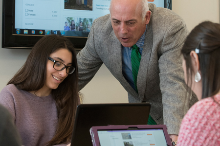 students working in classroom with faculty
