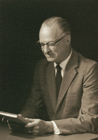 A portrait photograph of Chesley Husson looking at the cover of a book