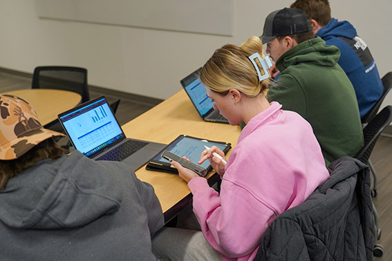 Students sitting in a class listening to a lecture at Husson University