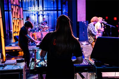 Students work at a live concert venue