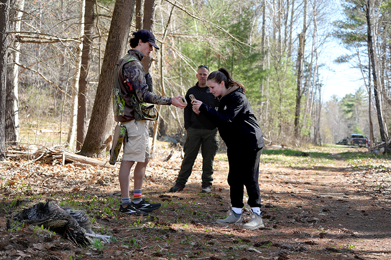 students work with a faculty member investigating a game crime scene