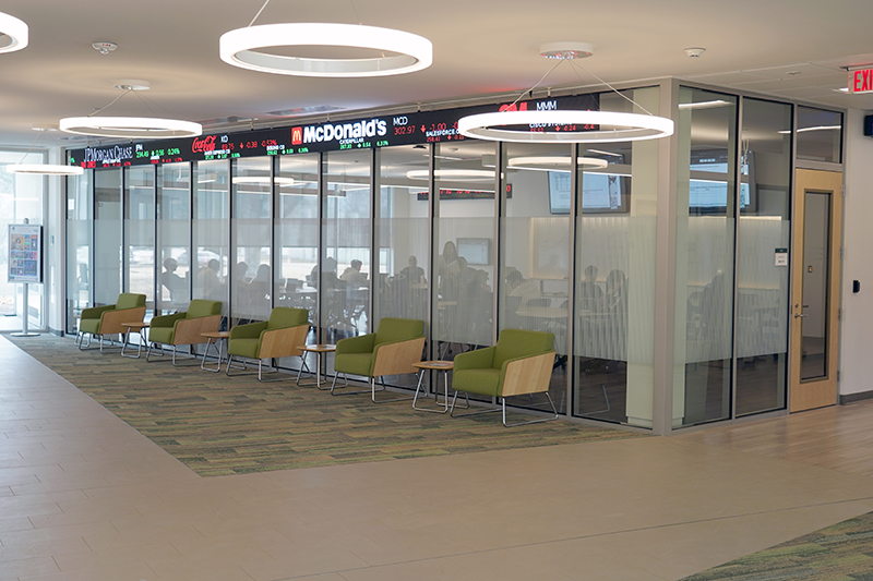The Ronan Center for Financial Technology, seen from outside the room, with a stock ticker on the wall and seating 