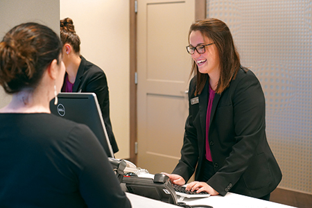 A hospitality employee works with a customer in a hotel lobby