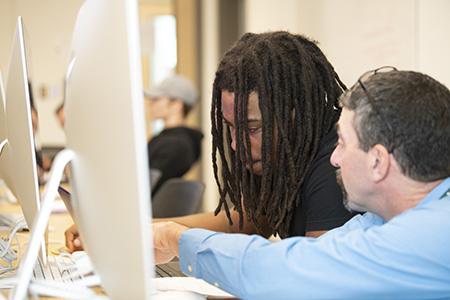 students and faculty work together in a computer lab