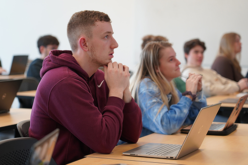 Students sitting in a class listening to a lecture at Husson University