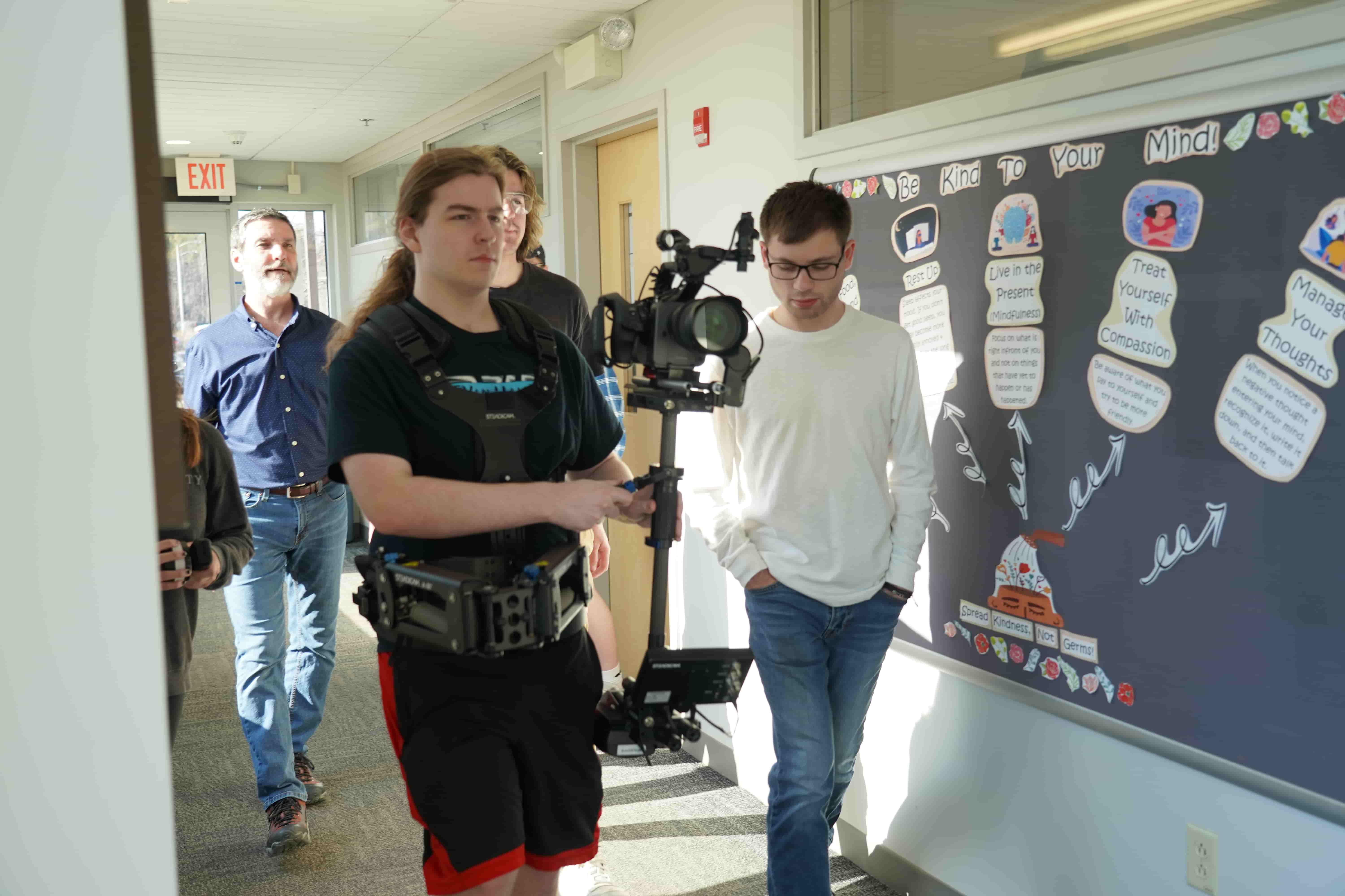 A student holding a video camera.