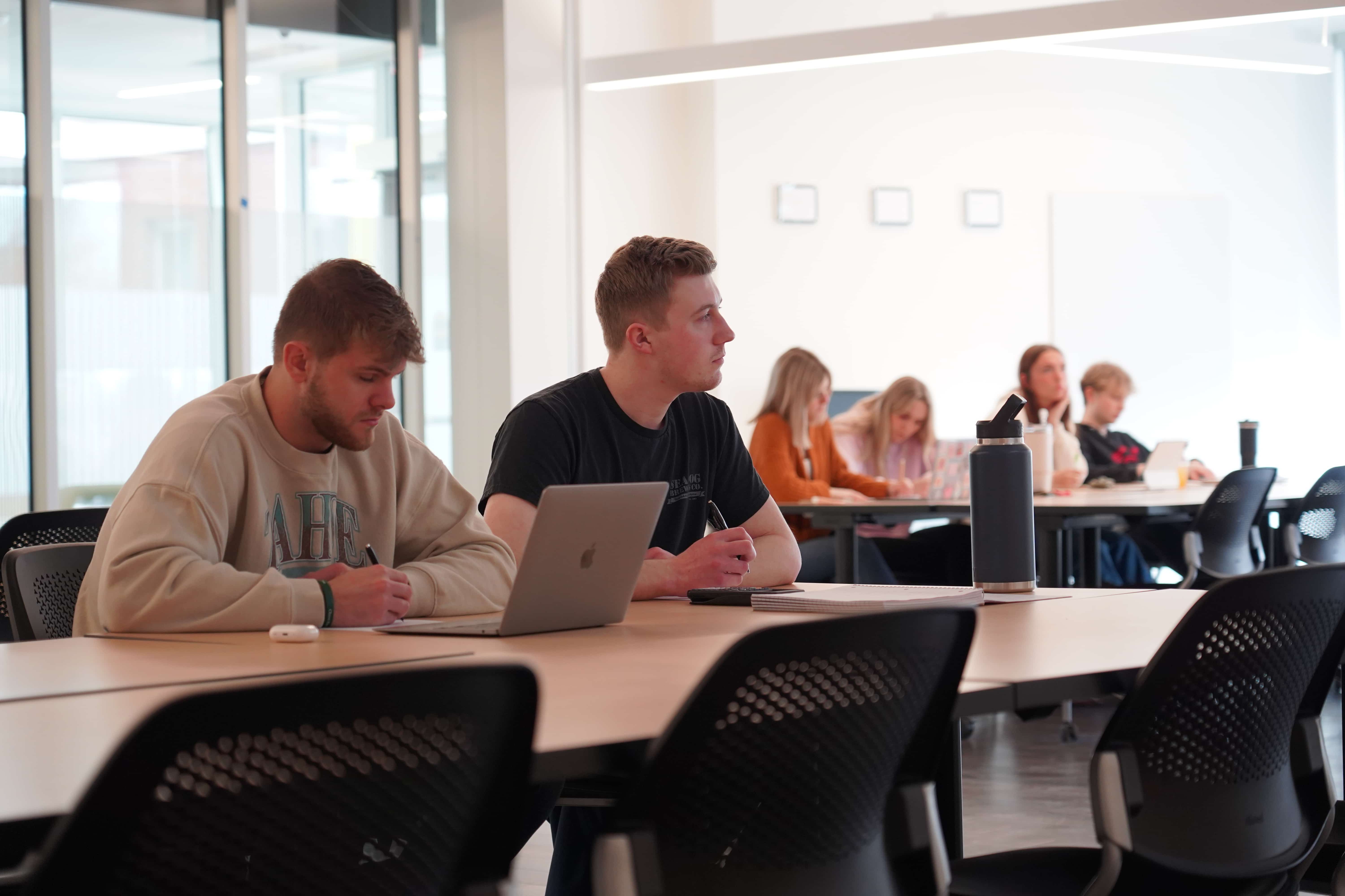 Two business students attending a class at Husson University.