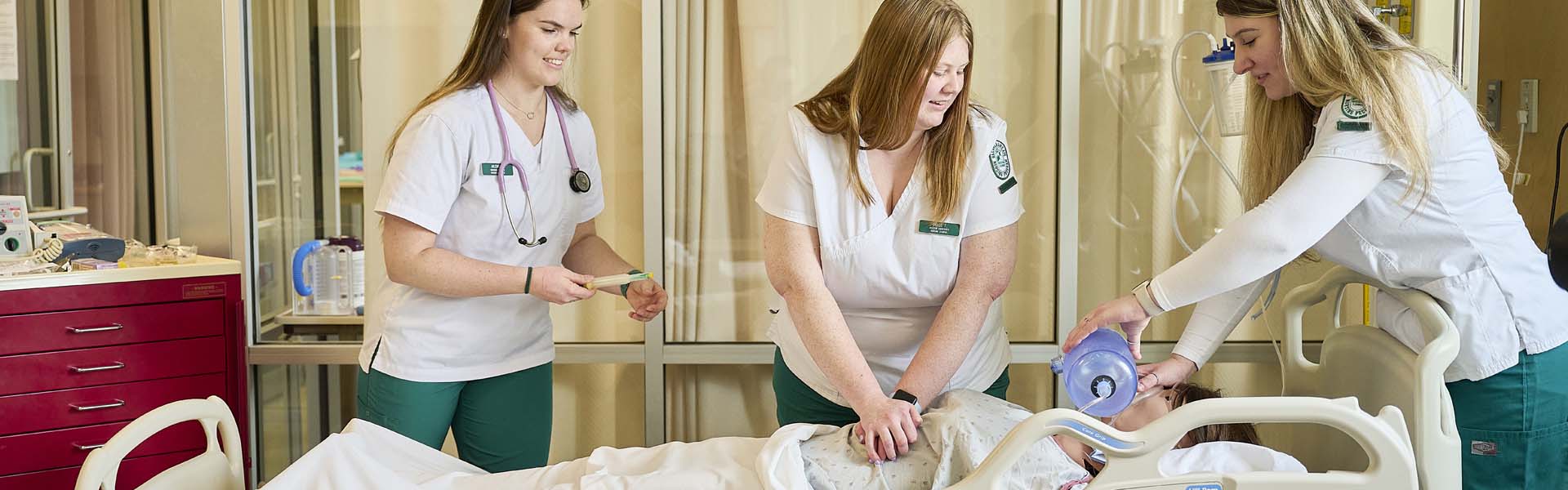 Nursing student works in a skills lab with a manequin