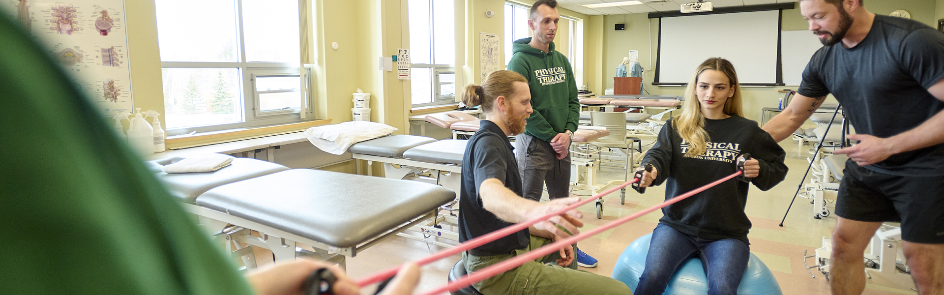 Students work in a Physical Therapy lab with faculty