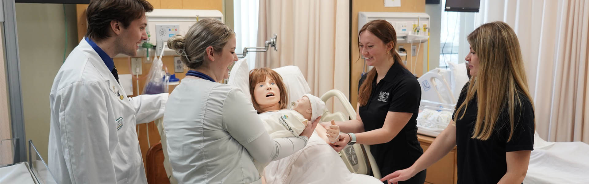 Nursing students work in a simulation lab with a manikin