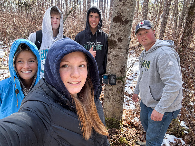 Students work in the field surveying wildlife and deploying game cameras