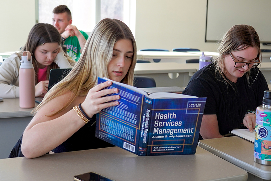 Students sitting in a class listening to a lecture at Husson University