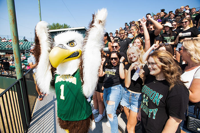 A packed crowd of students and Baldwin, the Husson University mascot, cheer during homecoming 2022.