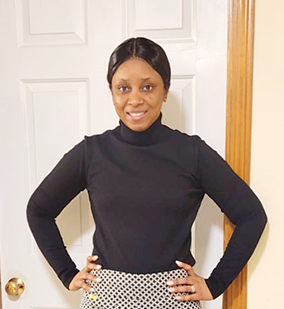 Isatu Barrie poses in front of door