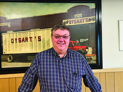 Tim Dysart stands in front of Dysart's business sign