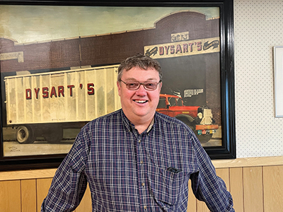 Tim Dysart stands in front of Dysart's business sign