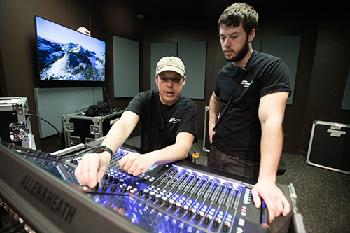 An audio engineering student works with a faculty member in an audio engineering lab