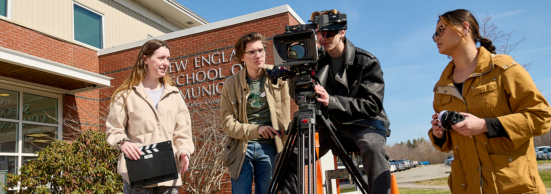 Students work on a camera during an outdoor video shoot