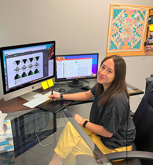 An image of a recent graduate working at a visual design studio