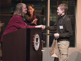 Kelly Mead, clinical supervision director for Husson University’s School of Education (left), congratulates this year’s winner of the Penobscot County Spelling Bee.  He is Neil St. John, a 13-year-old student who is in the 8th grade at Bangor Christian School.  He won by correctly spelling the word “herpetology.”