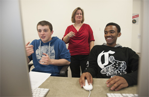 Faculty work with students in a lab