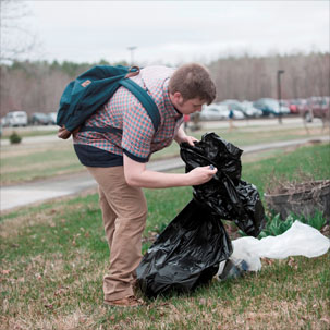 A student clears trash from campus on Earth Day