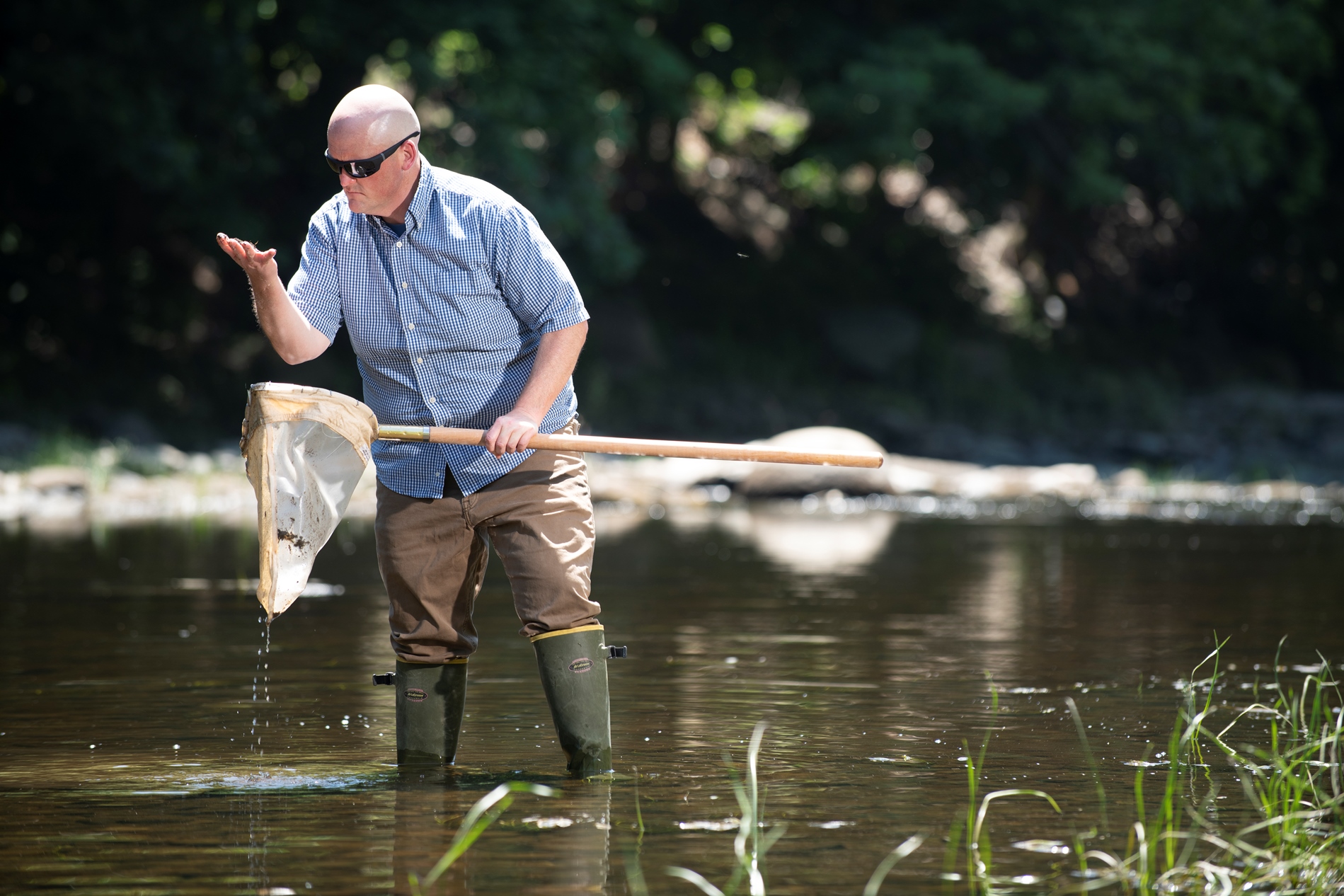 Robert Northington performs field work in a stream