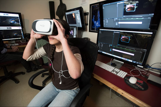 A student uses an extended reality headset to view a program created through VR software