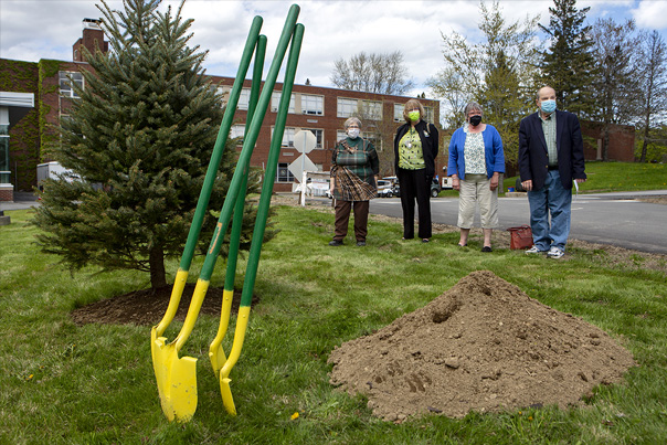 retirees plant a tree on the campus of Husson University