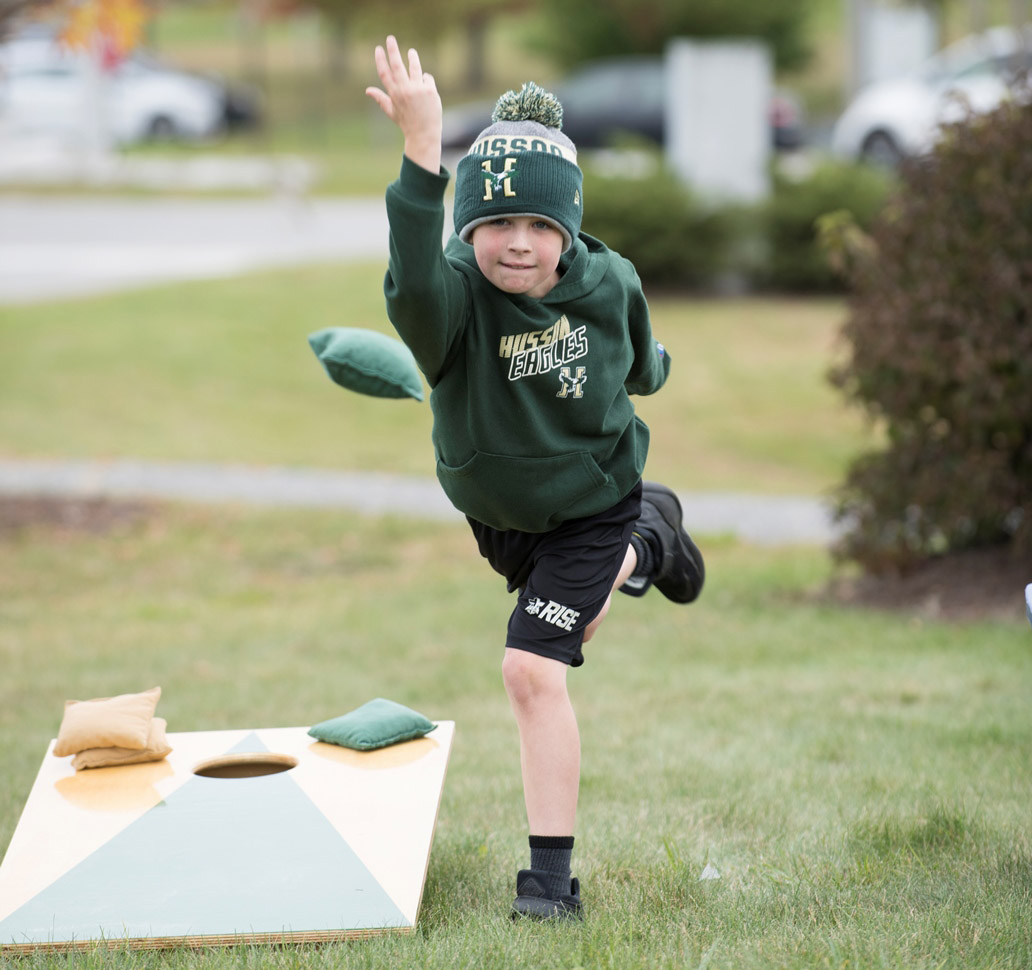 A child plays cornhole at Homecoming