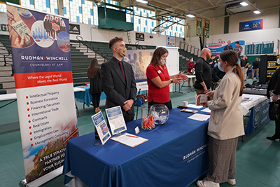 Student talking to two people at a table