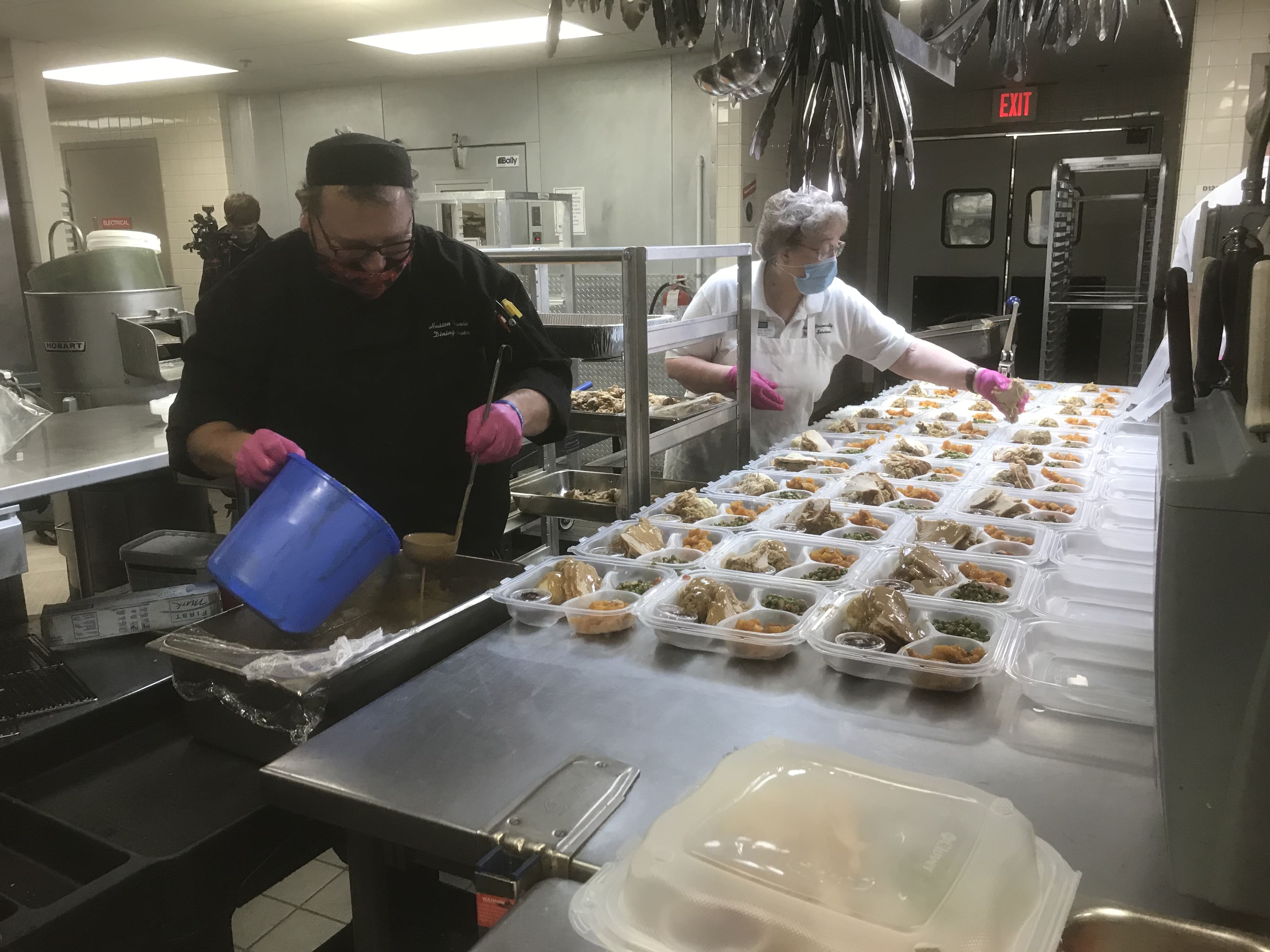 People prep food in a commercial kitchen